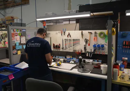 QTC technician at a repair workbench