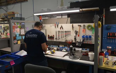 QTC technician at a repair workbench