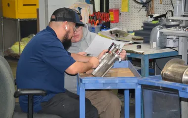 QTC technicians servicing a pneumatic valve assembly